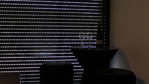 A room with a large window covered by blinds, a dark ottoman, and a chair. - Eco-lodges Lodges in Move - Domaine de Brau (Villemoustaussou)