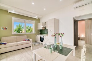 Un appartement moderne comprenant un coin repas, une kitchenette et un canapé.