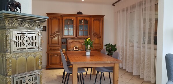 Un coin repas comprenant une table en bois, des chaises et un buffet aux portes vitrées.