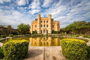 A castle-like building with a symmetrical facade, a central entrance, and a surrounding moat with water. - Livestay - Luxury 2bed Apartment With Free Parking (Slough)