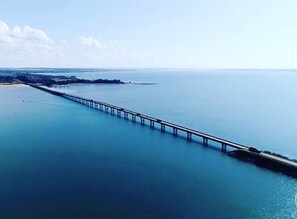 An aerial view of a long bridge extending into the water. - Buganville Villas (Itai)