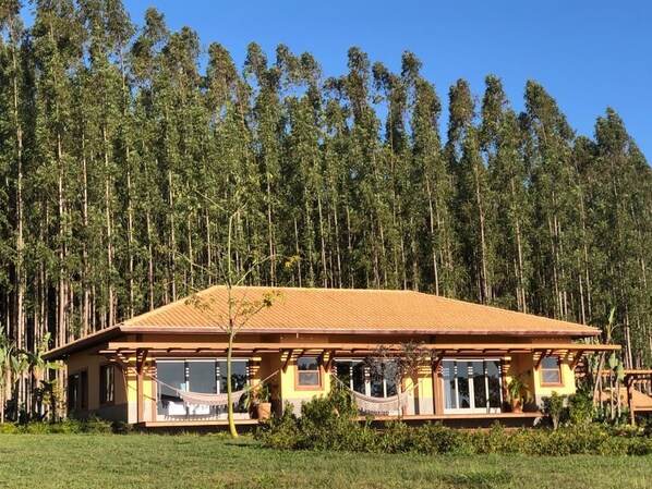 A two-story building with a flat roof, surrounded by a dense forest. - Buganville Villas (Itai)