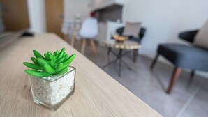 A modern living room with a dining area, featuring a glass table with a succulent plant. - APARTMENT 2 / BALCONY (Espinho)