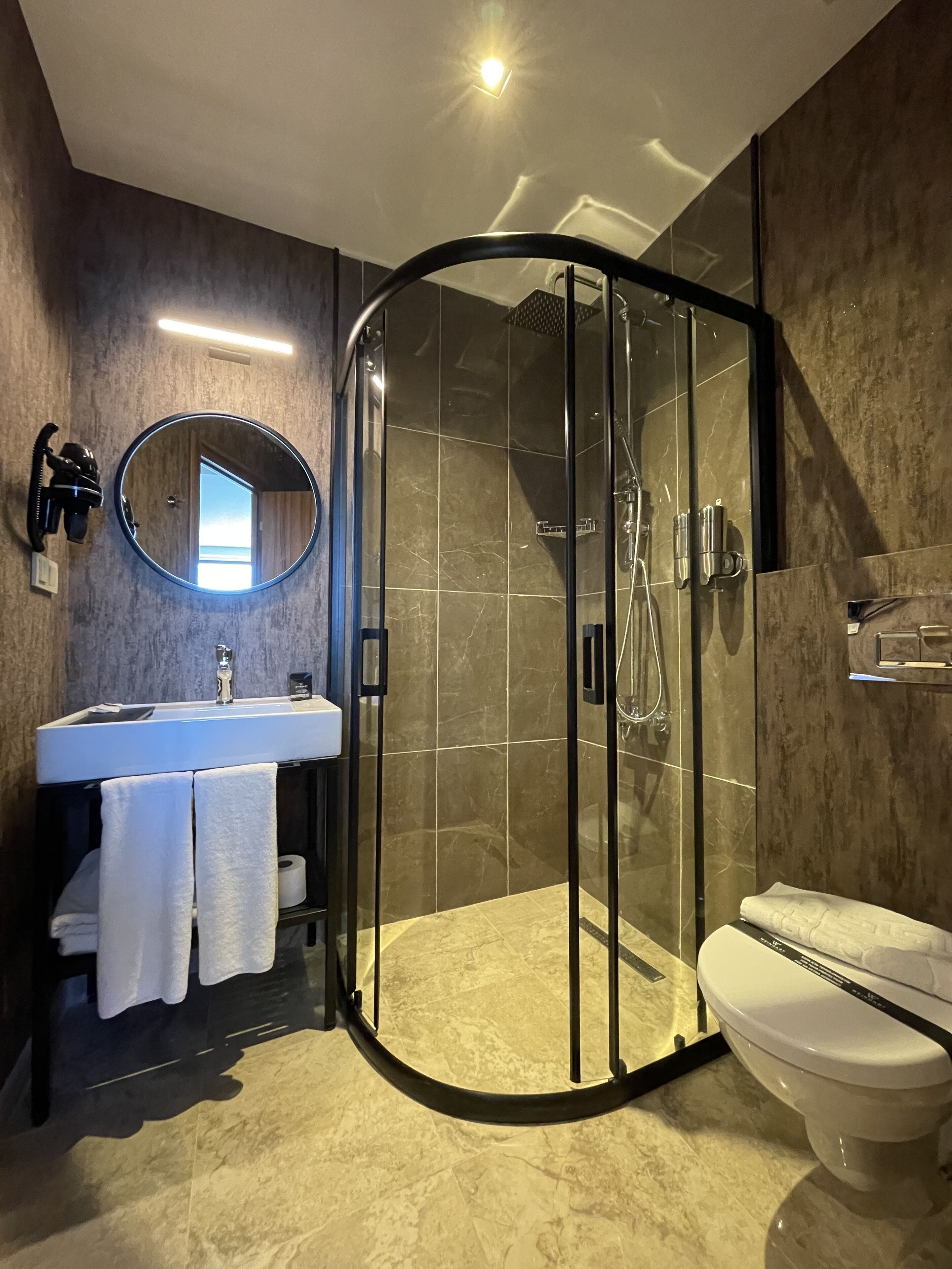 Douche, douche à « effet pluie », sèche-cheveux, peignoirs