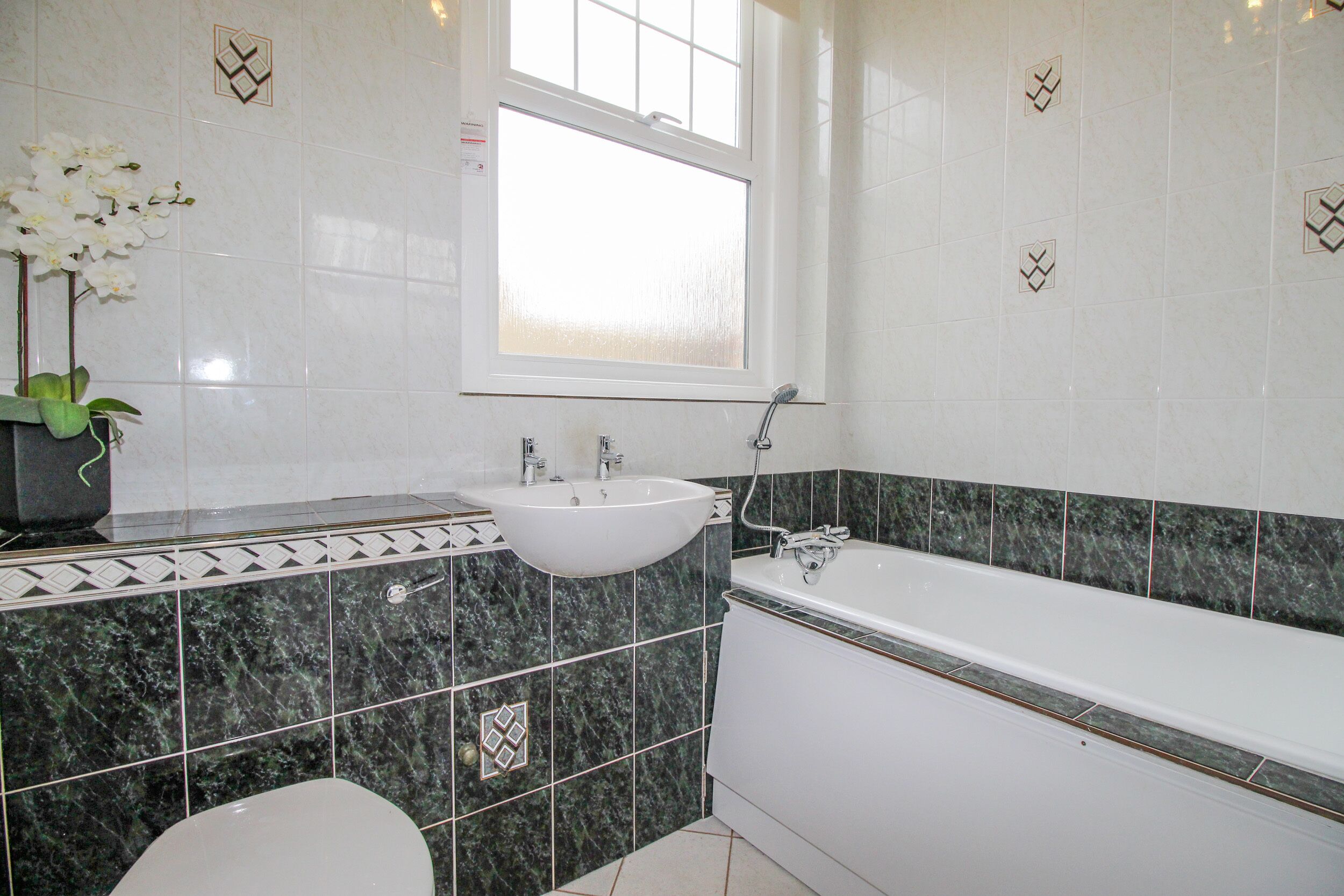 A bathroom with a white sink, a bathtub, and a toilet.