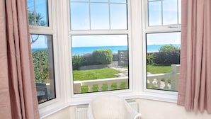 A corner room with three windows overlooking a garden and the sea. - Weymouth Bay Apartment A (Weymouth)