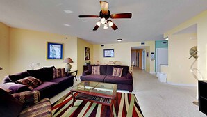 A living room with two sofas, a coffee table, and a ceiling fan. - Spacious Gulf Front Condo - Stunning Views + On-Site Amenities! (Navarre Beach)