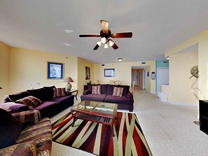 A living room with two sofas, a coffee table, and a ceiling fan.