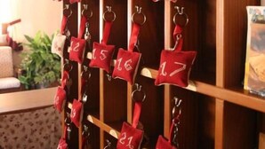 A wall with numbered keychains hanging on a wooden rack. - Hotel Piccola Mantova (Bosco Chiesanuova)