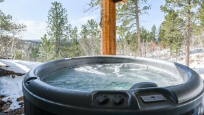 A hot tub outdoors with a wooden pergola overhead, surrounded by trees and a snowy landscape. - New 3-Level Lodge w/ Amazing View Close to Slopes & Trails w/ Great Amenities (Lead)