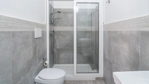A modern bathroom with a glass-enclosed shower, a toilet, and a bathtub. - THE STACKS 3 (Lido di Noto)