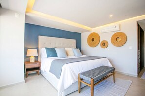Une chambre à coucher moderne avec un lit, une table de chevet, un banc et des éléments décoratifs muraux.