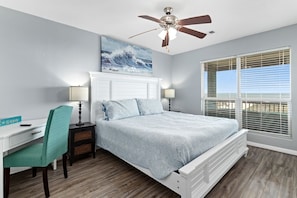 A bedroom with a bed, desk, chair, ceiling fan, and a window with blinds. - Beaches Be Trippin' 4 Bedroom Home by RedAwning (Port Bolivar)