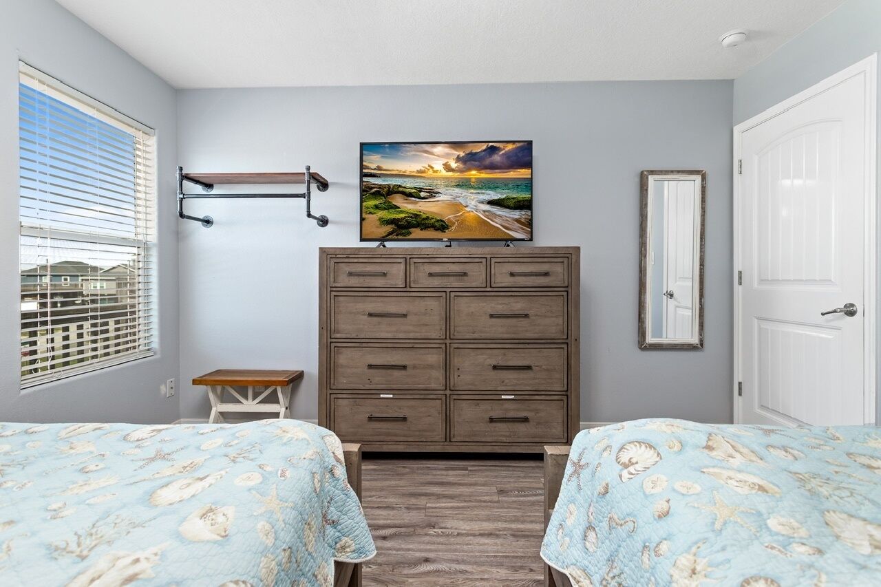 A bedroom with two beds, a dresser, a painting, and a window with blinds.