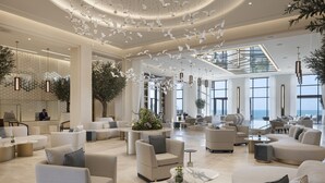 Un hall d’entrée spacieux, doté de meubles modernes, de grandes fenêtres et d’un plafond décoratif.