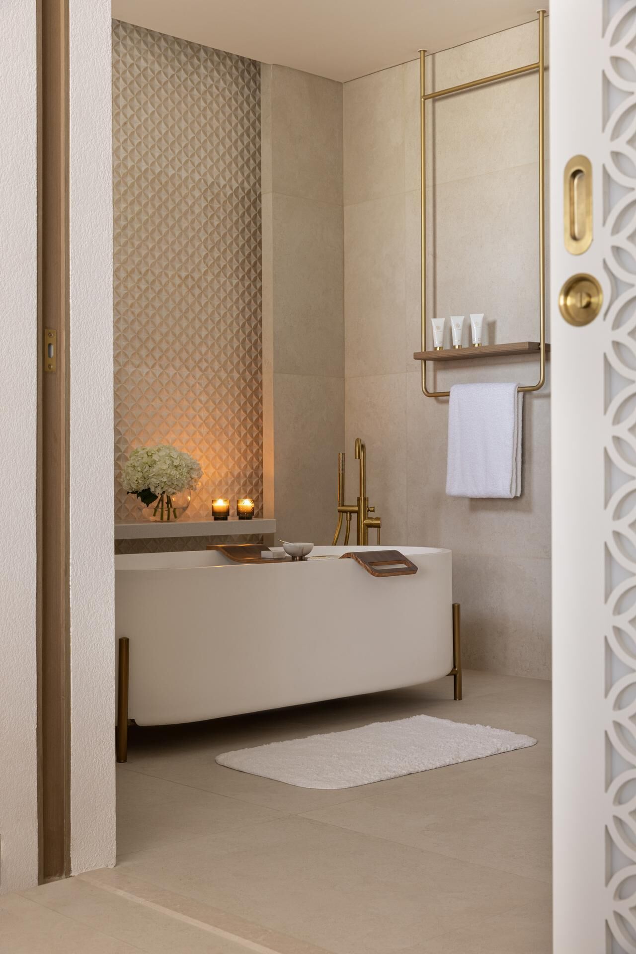 A modern bathroom with a large bathtub, a gold faucet, and a vanity with a mirror.