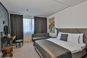 Une chambre d’hôtel moderne, dotée d’un grand lit, d’un bureau et d’une chaise.