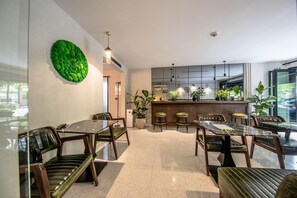 A modern interior with a dining area, kitchen, and bar. - Hotel Botanica (Belgrade)