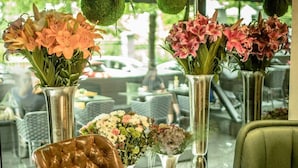 A seating area with a leather chair, a table, and vases of flowers.