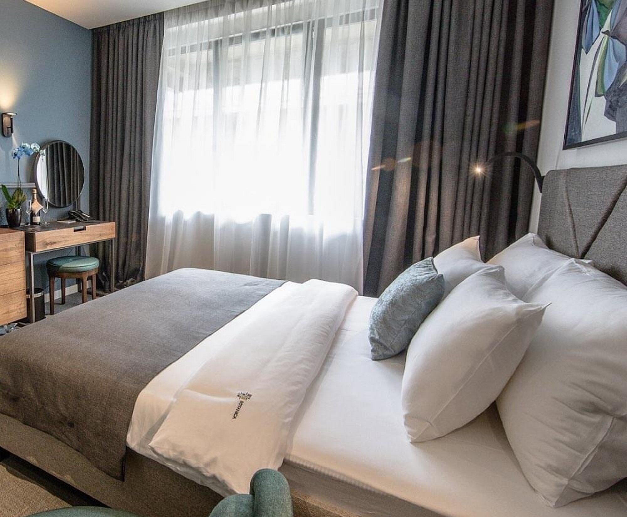 Una moderna camera d'hotel con un letto, una scrivania e una sedia.