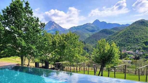 Une piscine avec vue sur les montagnes et un village.