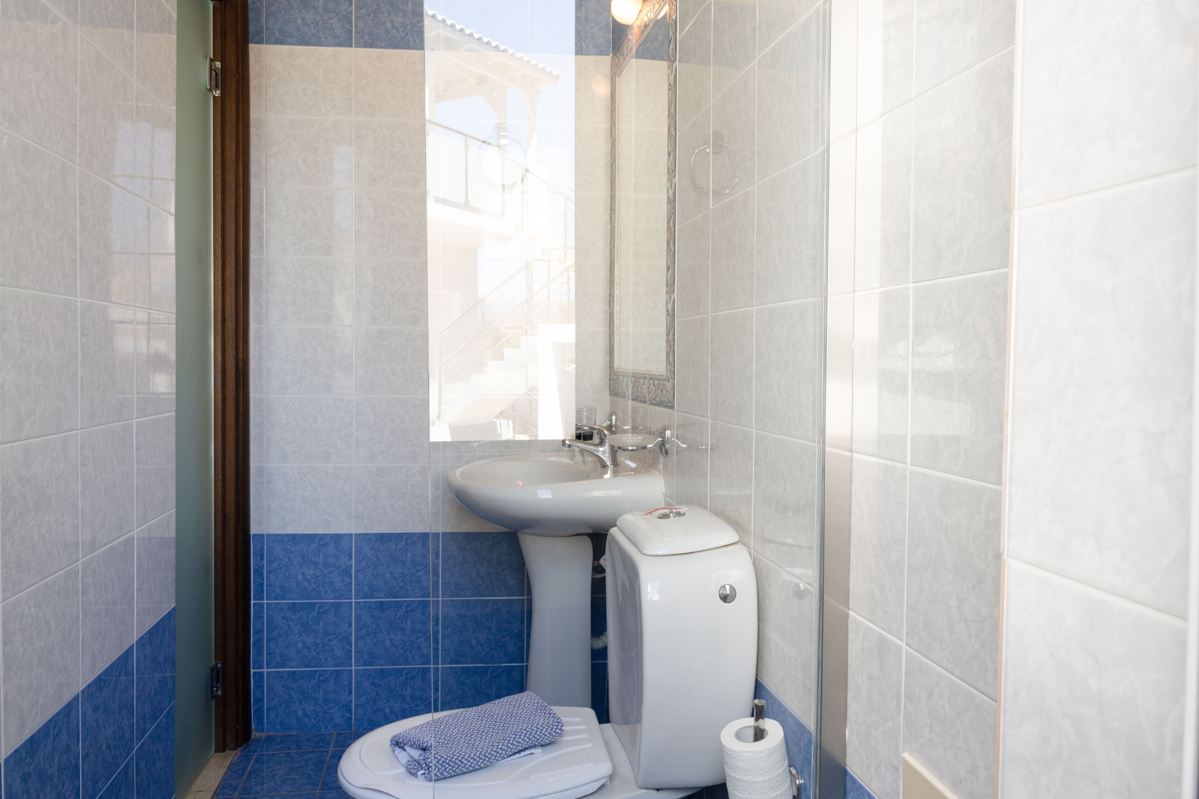 Une salle de bain avec des toilettes, un lavabo et un miroir.