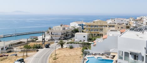 A coastal town with a swimming pool, buildings, and a road.