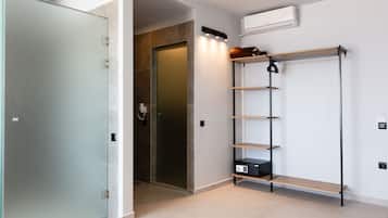 Een moderne badkamer met een douchecabine van glas, een houten wastafelmeubel en een ingebouwde plank.