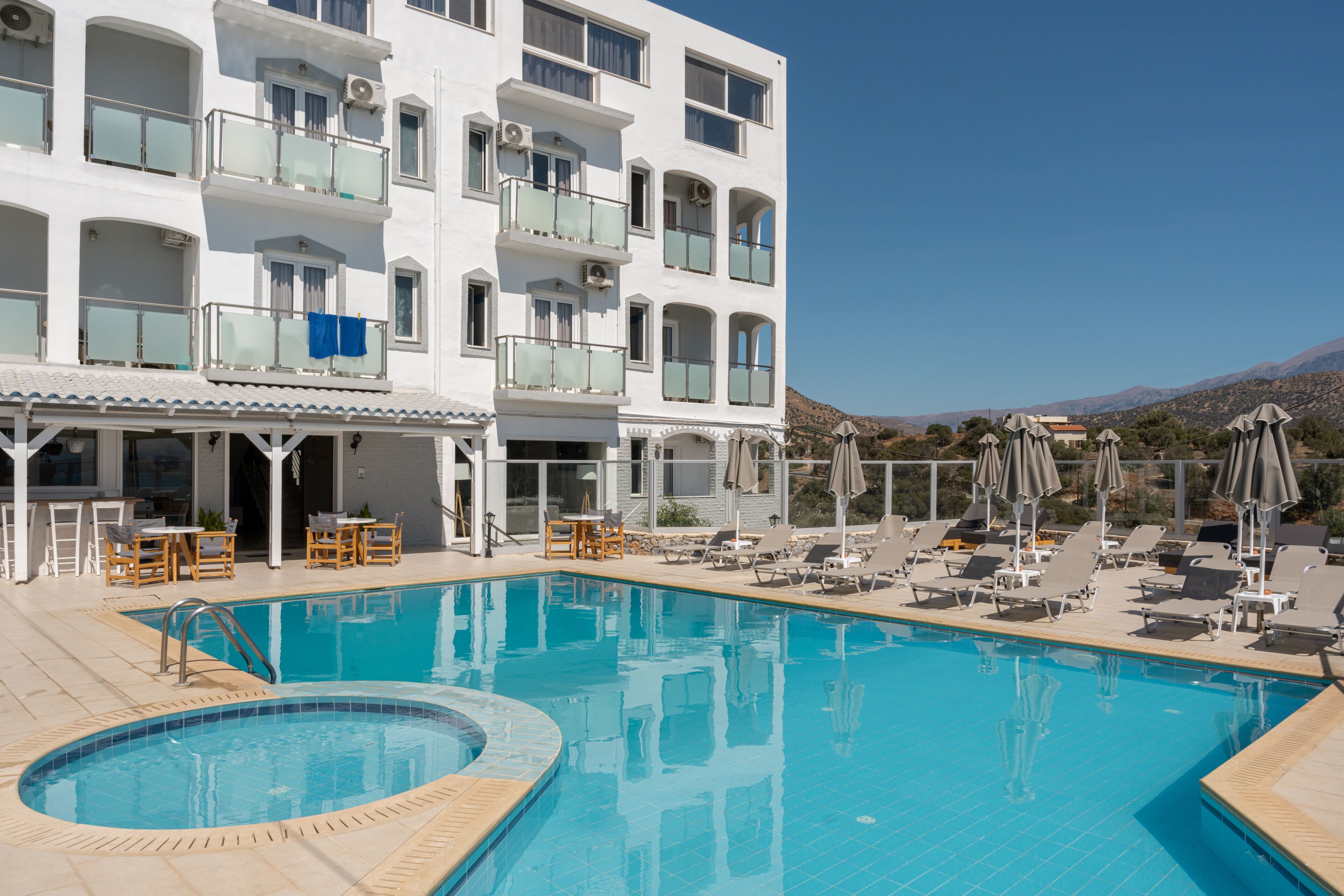 Un hôtel doté d’une piscine, d’un espace extérieur aménagé et offrant une vue sur les montagnes.