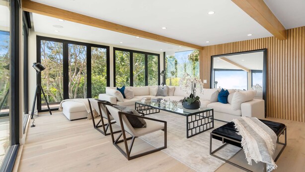 A modern living room with a large sofa, coffee table, and seating area.