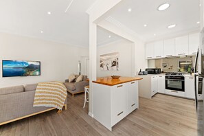 A modern apartment with a living area, kitchenette, and a dining space.