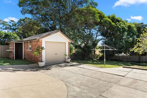 A residential garage with a brick exterior and a closed garage door.