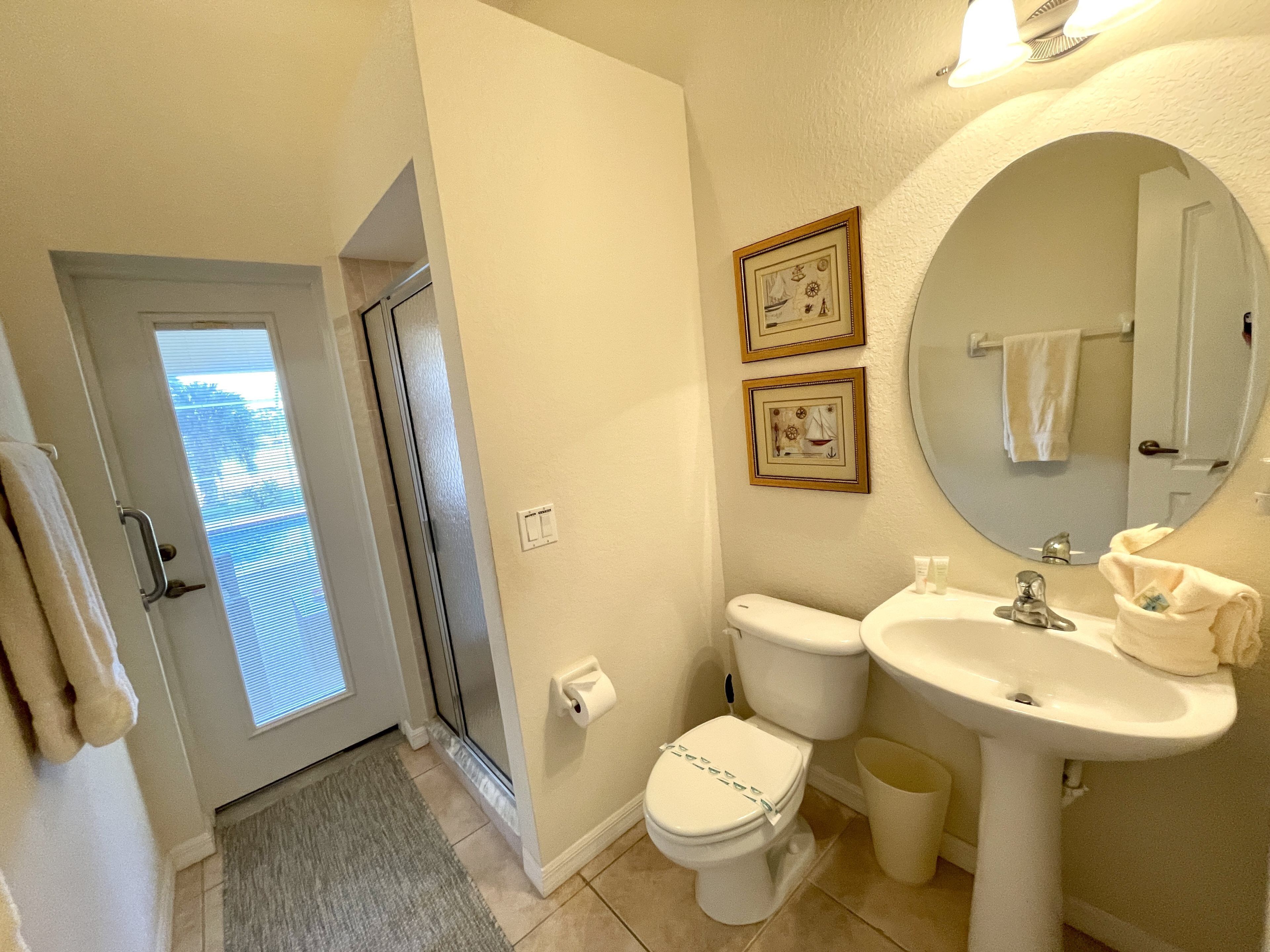 Une salle de bain équipée de toilettes, d’un bidet, d’un lavabo et d’un miroir.