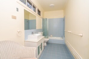 Een kleine badkamer met een wastafel, toilet en bad.
