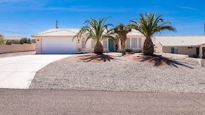 A residential property with a garage, a driveway, and two palm trees. - Tropical Heated Pool & Sunset Views Oasis (Lake Havasu City)