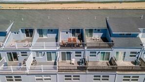 Un immeuble à plusieurs étages doté de balcons donnant sur une plage.