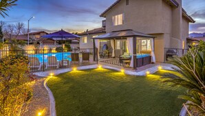 Propiedad residencial con piscina, mobiliario de exterior y zona de patio cubierta.
