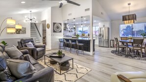 Una sala moderna con sofá, una mesa de centro y un comedor con sillas y una mesa.