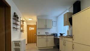 A compact kitchen with light-colored cabinets, a microwave, a toaster, and a sink. - Ferienhaus Möhrle 1 (Ueberlingen)