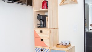 A multi-tiered wooden storage unit with various compartments, a red kettle, and a coffee maker on the middle shelf. - BAIRRO ALTO MUSIC GUEST HOUSE CHOPIN (Lisboa ciudad)