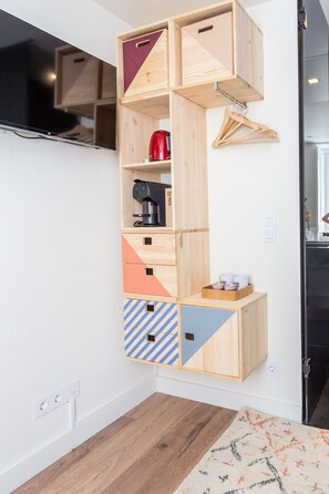 A multi-tiered wooden storage unit with various compartments, a red kettle, and a coffee maker on the middle shelf. - BAIRRO ALTO MUSIC GUEST HOUSE CHOPIN (Lisboa ciudad)