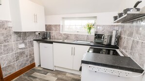 Een moderne keuken met witte kasten, een zwart aanrechtblad en een ingebouwde oven.
