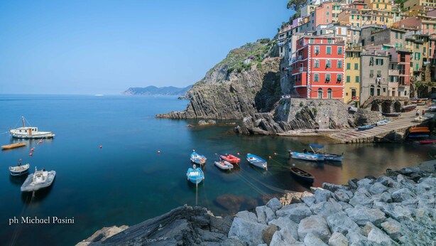 A coastal town with colorful buildings, boats, and rocky terrain.