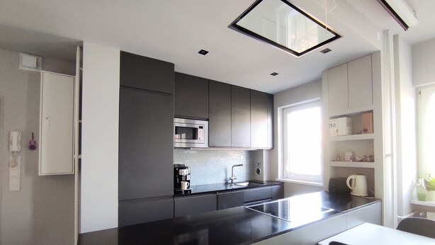 A modern kitchen with a black countertop, stainless steel appliances, and white cabinetry. - Recently refurbished flat, very well connected and close to Mauerpark (Berlin)