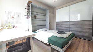 A modern bedroom with a bed, a desk, and a wardrobe. - Recently refurbished flat, very well connected and close to Mauerpark (Berlin)