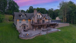 A large house with a patio area, outdoor seating, and a fire pit. - Black Diamond Retreat | Lakefront w/ Dock + Game Room! (Pottsville)