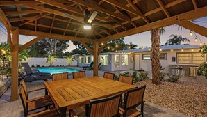 Un patio extérieur abrité, doté d’une piscine, d’une table à manger et de chaises.