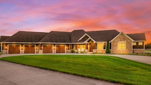 A large, multi-story house with a well-maintained lawn and a driveway. - Kountry Lane Stables | Horse Farm w/ HOT TUB + Fire Pit! (Wakarusa)