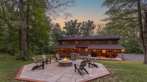 Une cabane dotée d’un patio comprenant un espace salon extérieur et un foyer.