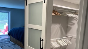 A bedroom with a sliding closet door, a bed, and a view of the outdoors. - Home away  Harwich (Harwich)